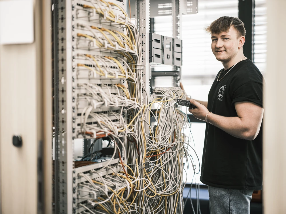 Lehrling Claudio Bodendorfer vor einem Serverschrank